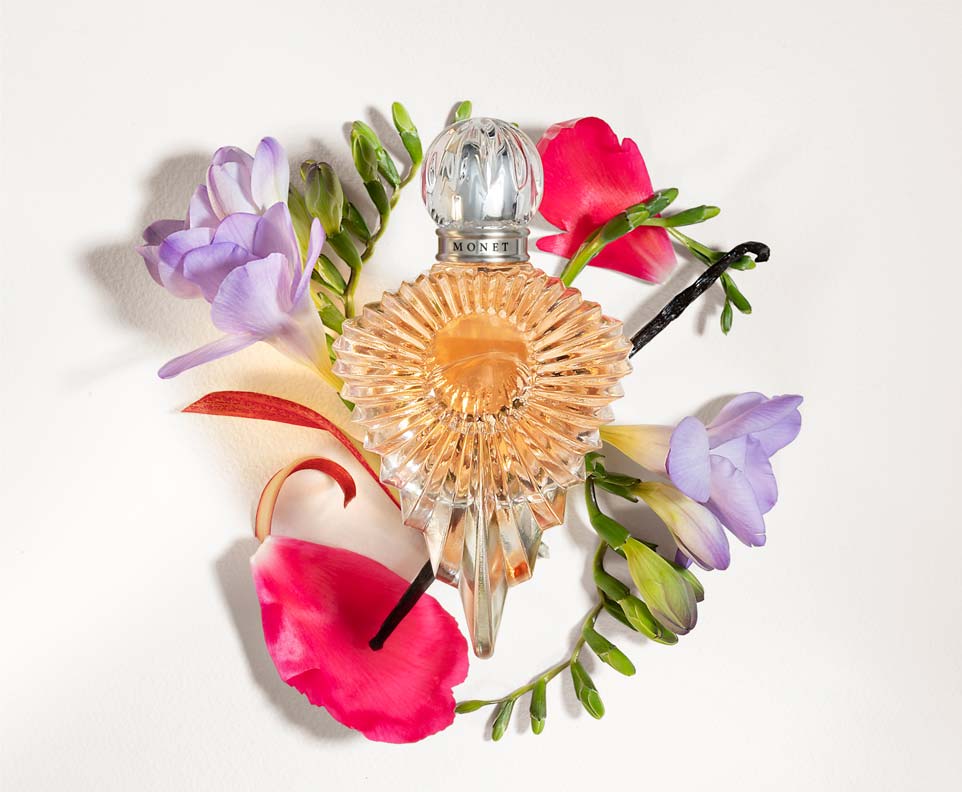 Monet's fragrance bottle surrounded by flowers
